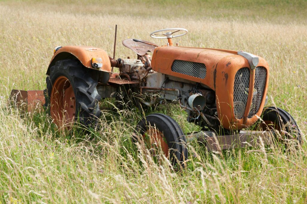 Rusty tractor left in a grassy field in Villard-de-Lans, France.
